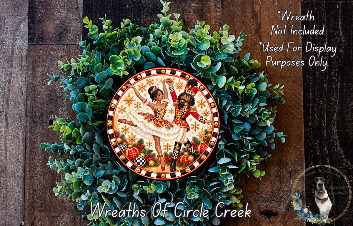 A wreath made of green leaves and a decorative plate featuring a dancing couple.