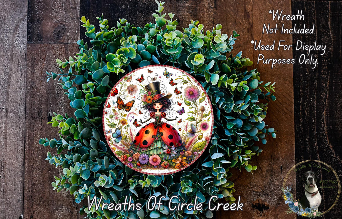 A wreath made of various green plants and flowers, with a central circular design featuring a woman wearing a top hat and surrounded by butterflies and flowers.