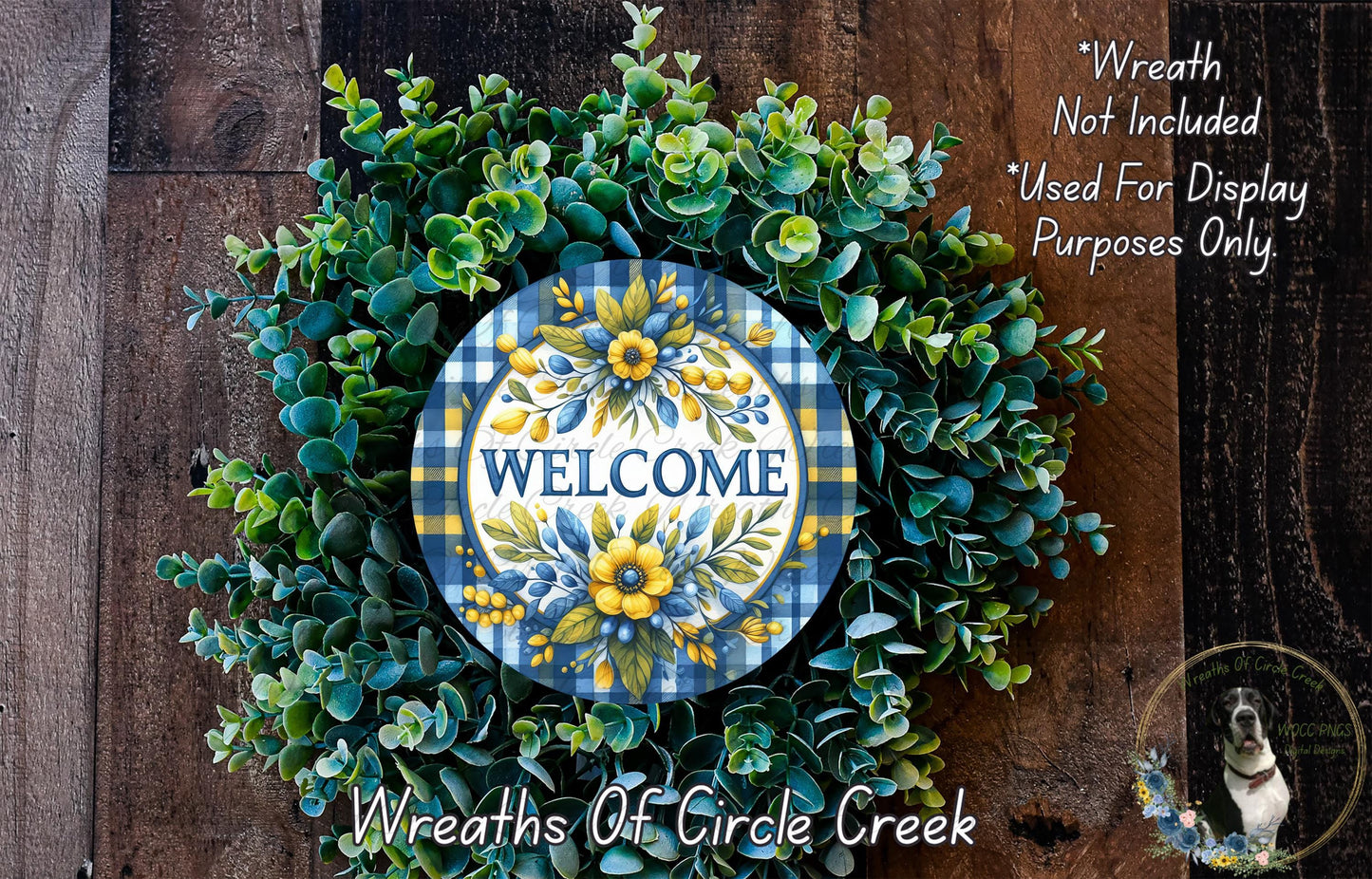 a wreath with a "Welcome" sign in the center, surrounded by various green and yellow flowers and leaves. The wreath is displayed on a wooden surface, and there is a small dog in the bottom right corner.