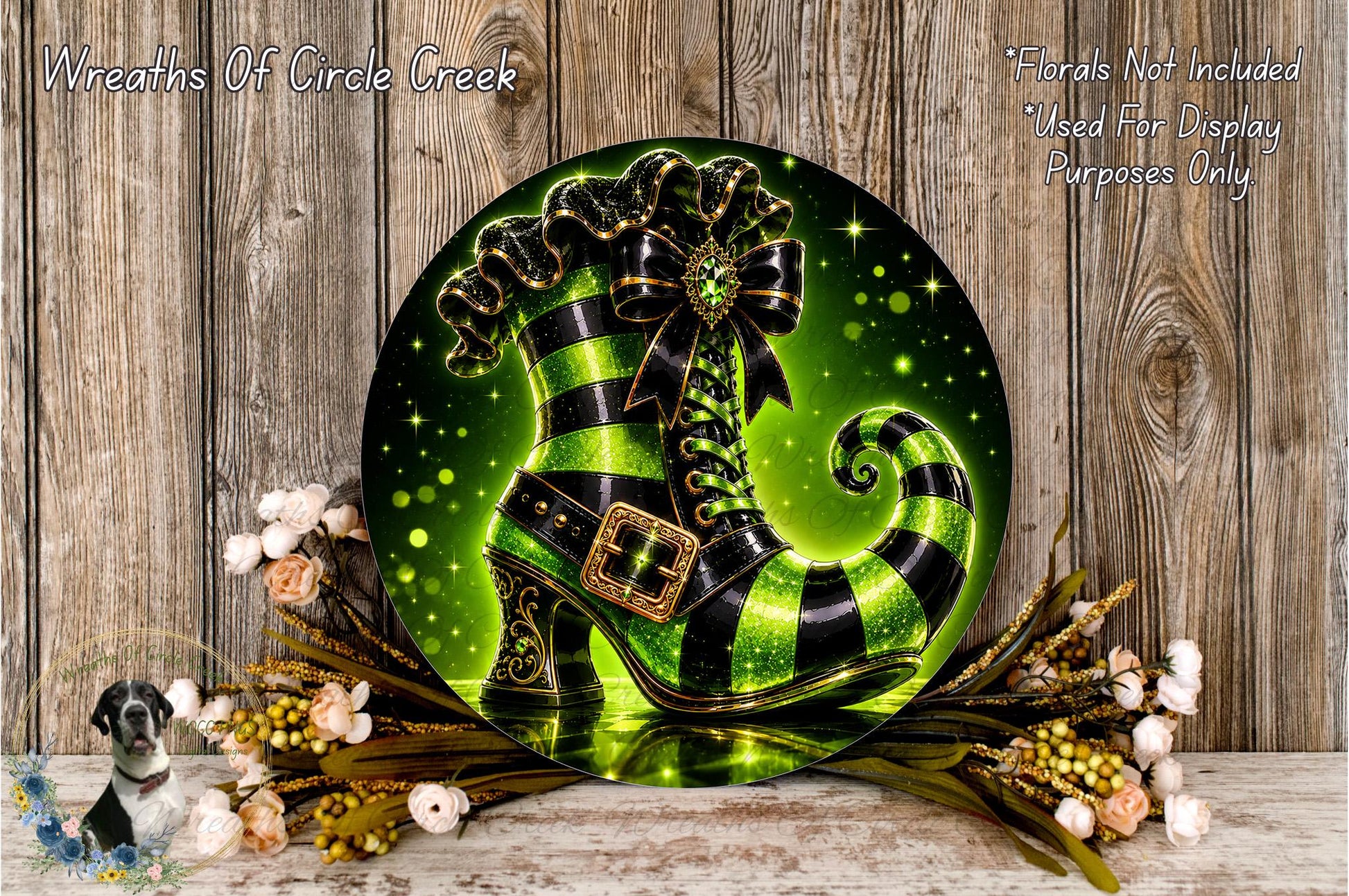 A decorative wreath featuring a green and black striped witch's boot, surrounded by flowers and a wooden background.