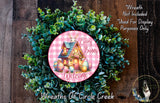 a wreath with a pink and green design, surrounded by greenery, and a small house illustration. The wreath is described as a "Welcome Wreath" and is not included in the "Purposes Only" list. The text "Wreath Not Included * Used For Display Only" is also present.