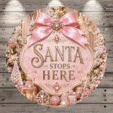 a festive Christmas scene with a pink ribbon and a sign that reads "Santa stops here". The background includes a snowy landscape with trees and ornaments, creating a winter wonderland atmosphere.
