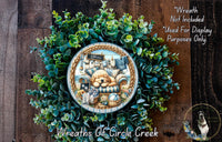 a wreath with a dog and various objects, including a sign that says "Welcome". The wreath is surrounded by a lush green plant, and there is a small dog in the bottom right corner of the image.
