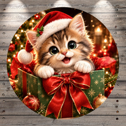 A cute kitten wearing a Santa hat and sitting in a gift box with a red bow, surrounded by Christmas decorations and ornaments.
