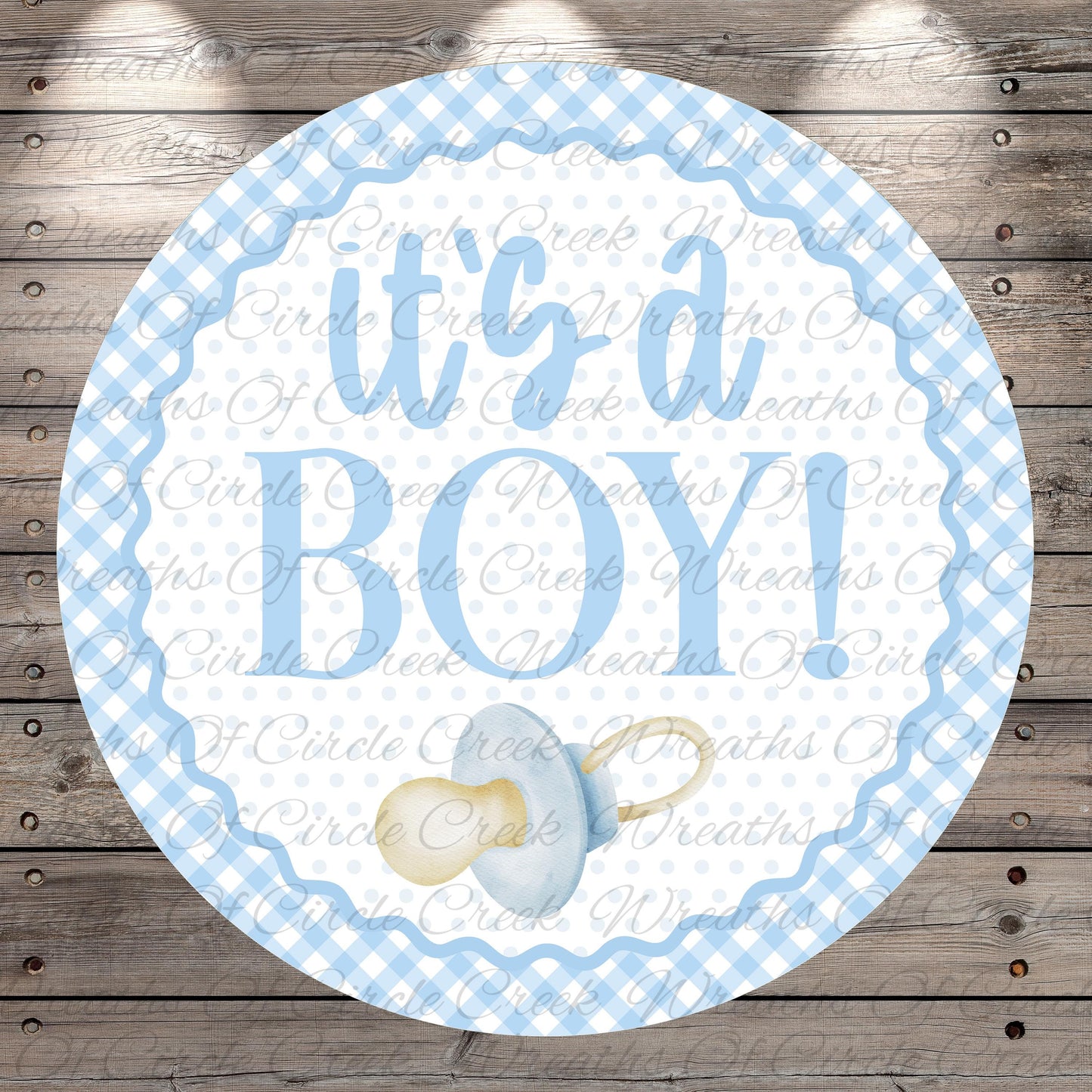 A round blue and white baby announcement sign with the text "It's a BOY!" and a pacifier icon.