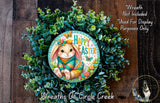 A wreath made of green leaves and flowers, featuring a cartoon rabbit wearing a sweater and a "Happy Easter" sign.