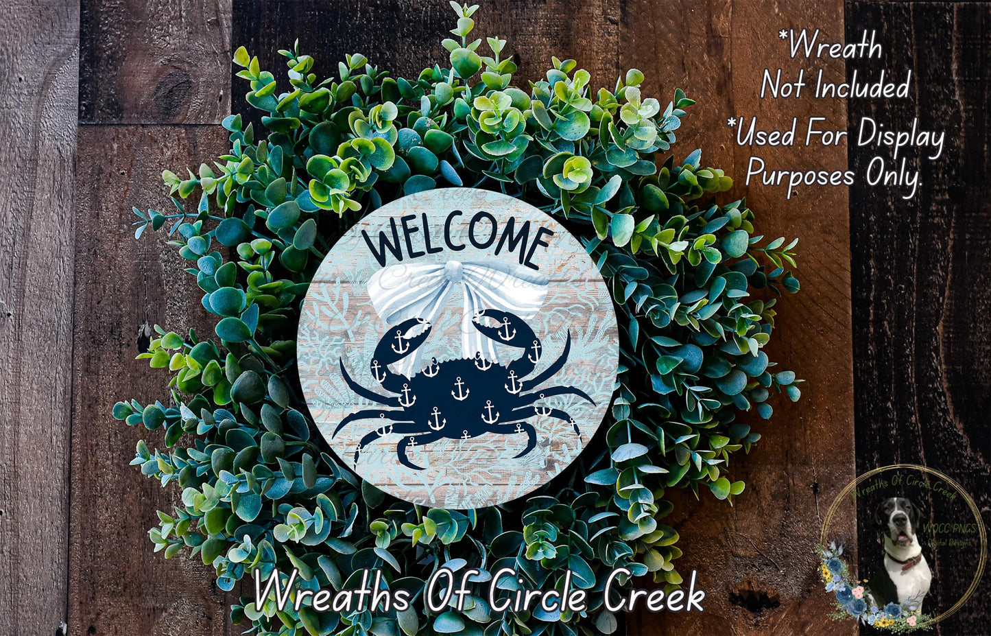 a wreath with a crab design and the word "WELCOME" written on it, placed on a wooden surface.