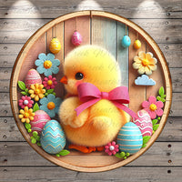 A round wooden wreath with a yellow chick wearing a pink bow, surrounded by colorful Easter eggs, flowers, and other decorative elements.