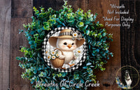A wreath featuring a cartoon chicken holding a basket of flowers, surrounded by a lush green plant.