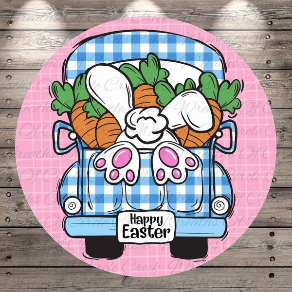 A cartoon illustration of a blue and white checkered truck with a bunny sitting in the back, surrounded by carrots. The text "Happy Easter" is displayed on the truck.