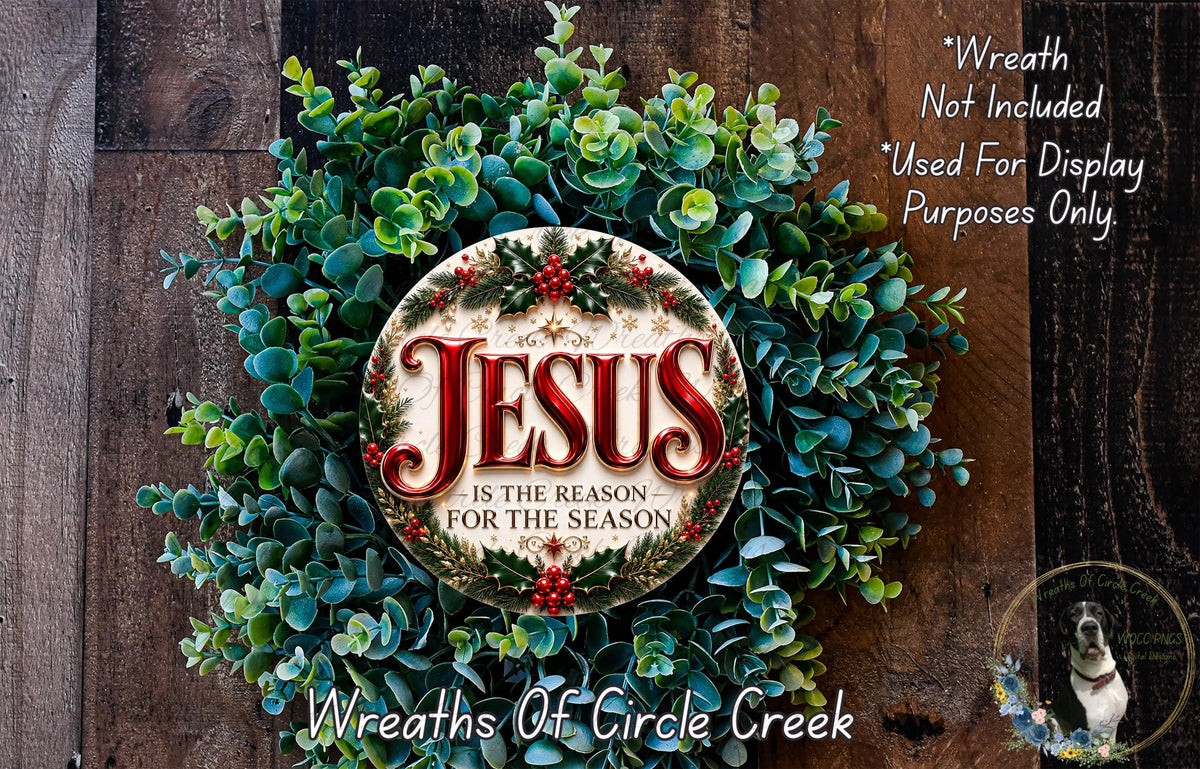 a Christmas wreath with the text "Jesus is the reason for the season" displayed on it. The wreath is made of green and red foliage, and there is a small dog in the bottom right corner of the image.
