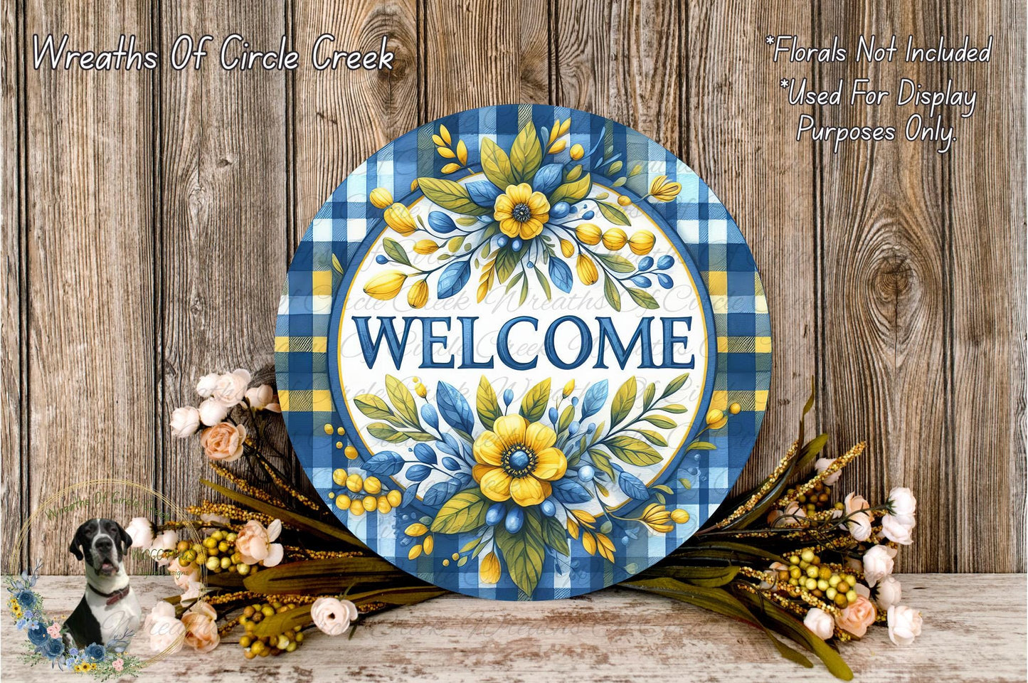 a decorative welcome sign with a blue and white plaid pattern, surrounded by a floral arrangement of flowers and greenery.