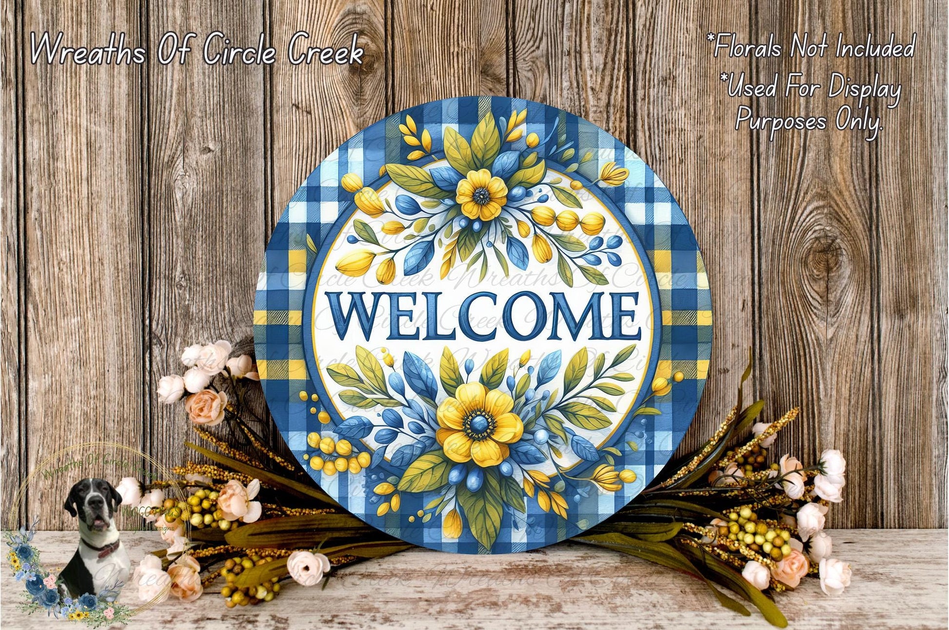 a decorative welcome sign with a blue and white plaid pattern, surrounded by a floral arrangement of flowers and greenery.