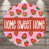 a circular design with a repeating pattern of red and white strawberries on a pink and white checkered background. The text "HOME SWEET HOME" is prominently displayed in the center of the design.
