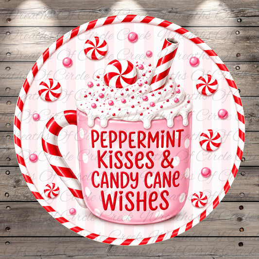 A pink mug filled with whipped cream and surrounded by red and white striped candy canes, with the text "Peppermint Kisses & Candy Cane Wishes" written on the mug.