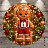 A gingerbread man figure wearing a red bow tie and red and white striped pants, standing in front of a Christmas tree decorated with red and gold ornaments and surrounded by holly leaves and berries.