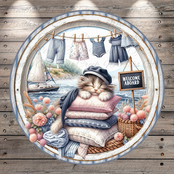 A sleeping cat wearing a hat and scarf is surrounded by various nautical elements, including a sailboat, clothesline, and a "Welcome aboard" sign, all set against a backdrop of a seascape.