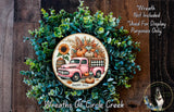A wreath made of green foliage and featuring a pink vintage truck with a pumpkin and sunflowers, surrounded by the text "Happy Fall" and "Wreaths of Circle Creek".