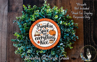 a wreath made of green leaves and a decorative orange and white sign that says "Pumpkin Spice and everything Nice".