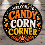 a circular sign with the text "Welcome to Candy Corn Corner" in a decorative font, surrounded by candy corn and other Halloween-themed elements.