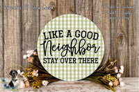 a round wooden sign with the text "Like a good Neighbor, Stay over there" written on it, surrounded by a floral arrangement and a wooden wall.