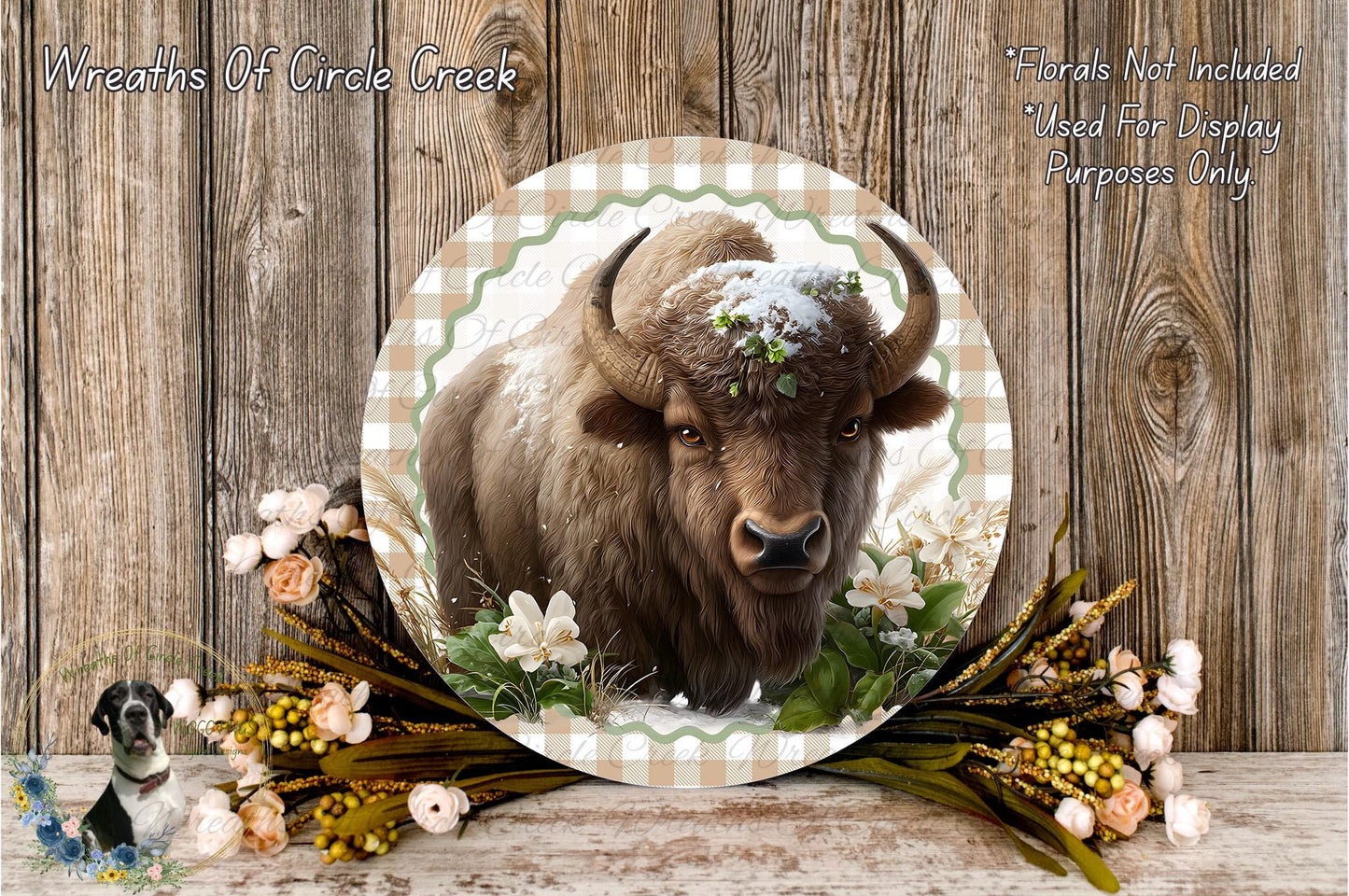 A close-up of a bison with a snow-covered head, surrounded by flowers and foliage, set against a rustic wooden background.
