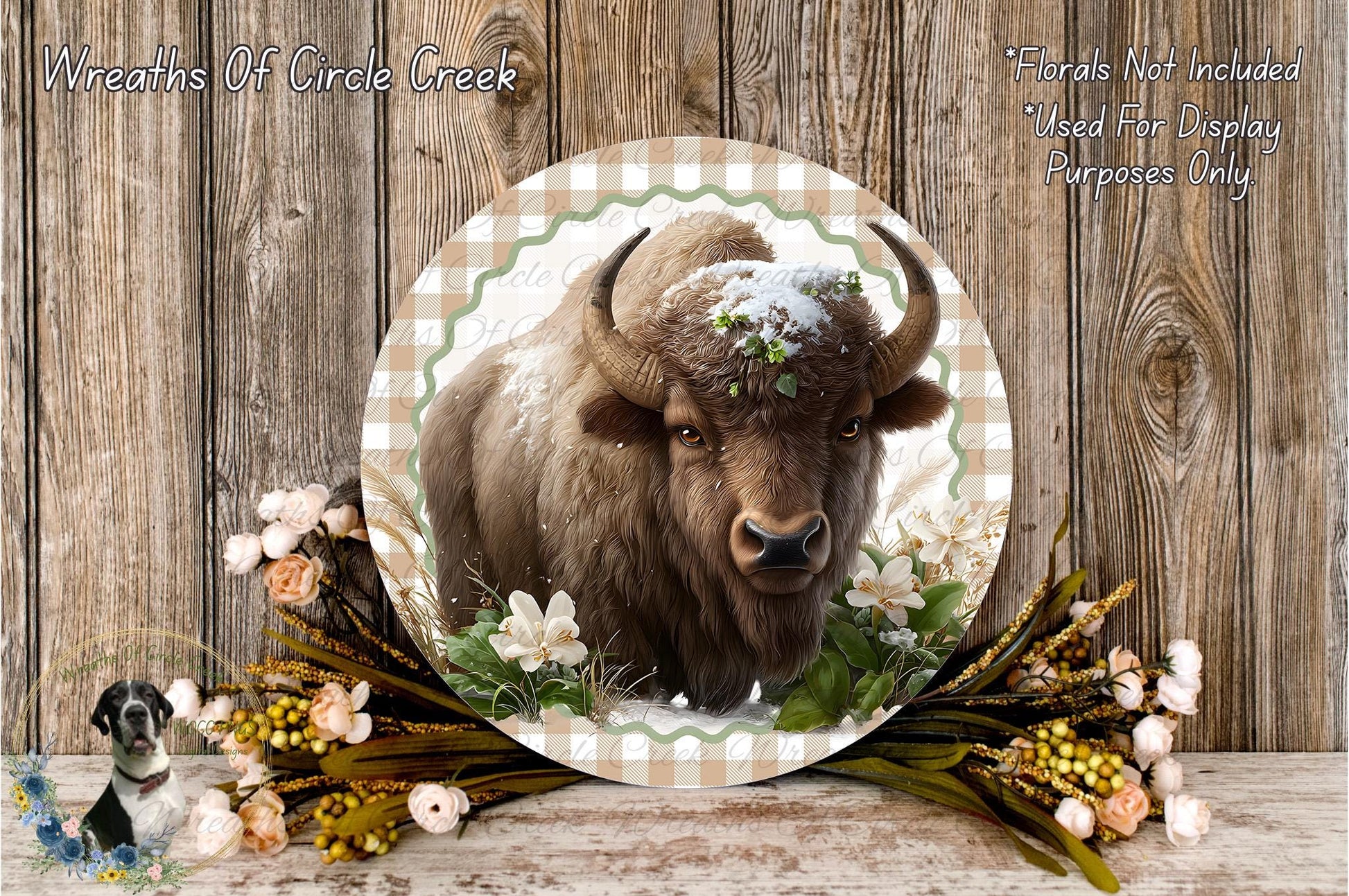 A close-up of a bison with a snow-covered head, surrounded by flowers and foliage, set against a rustic wooden background.