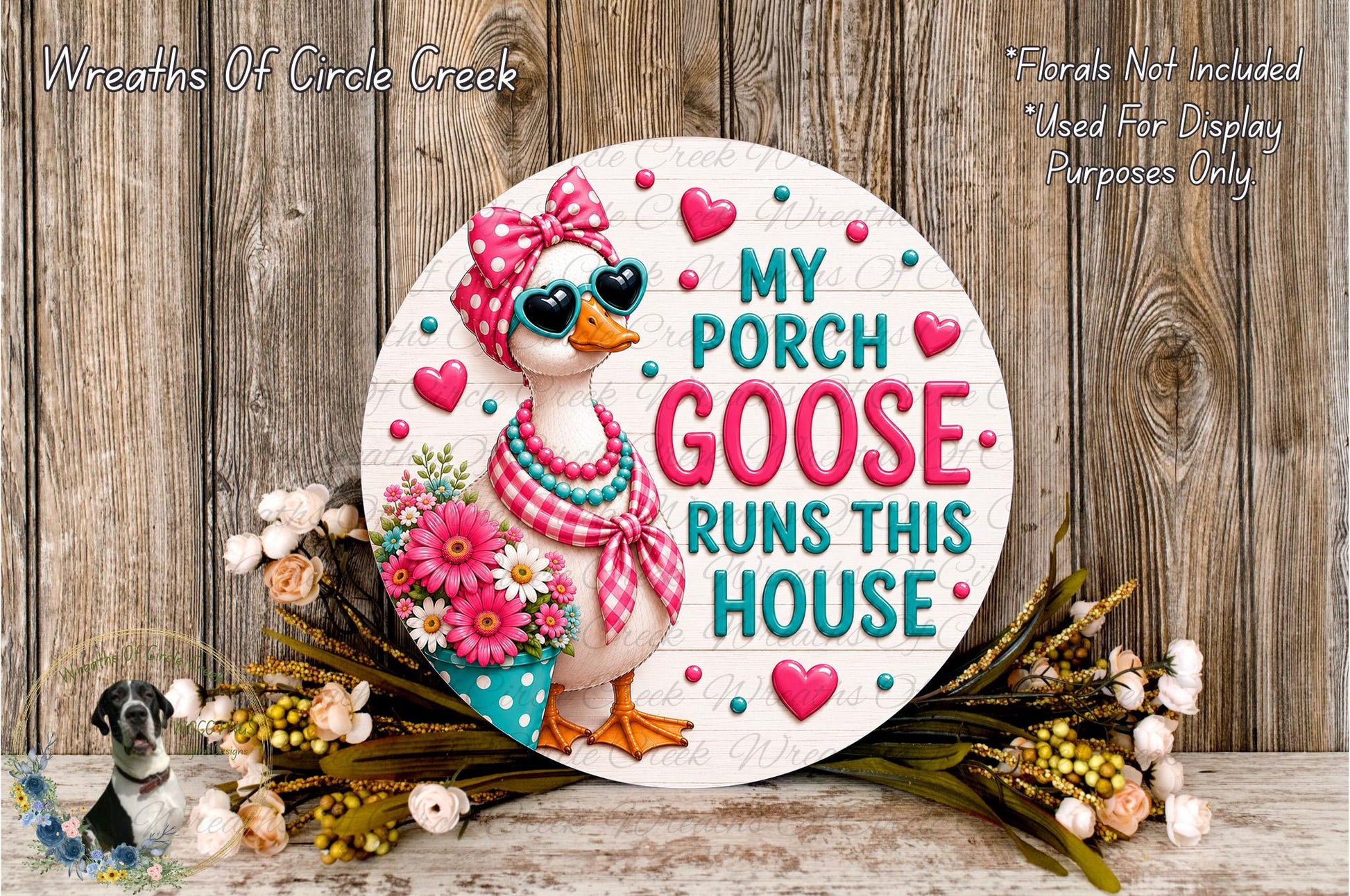 a decorative sign with a cartoon goose wearing sunglasses and a bow, surrounded by flowers and greenery. The sign has the text "My Porch Goose Runs This House" and is placed on a wooden surface.