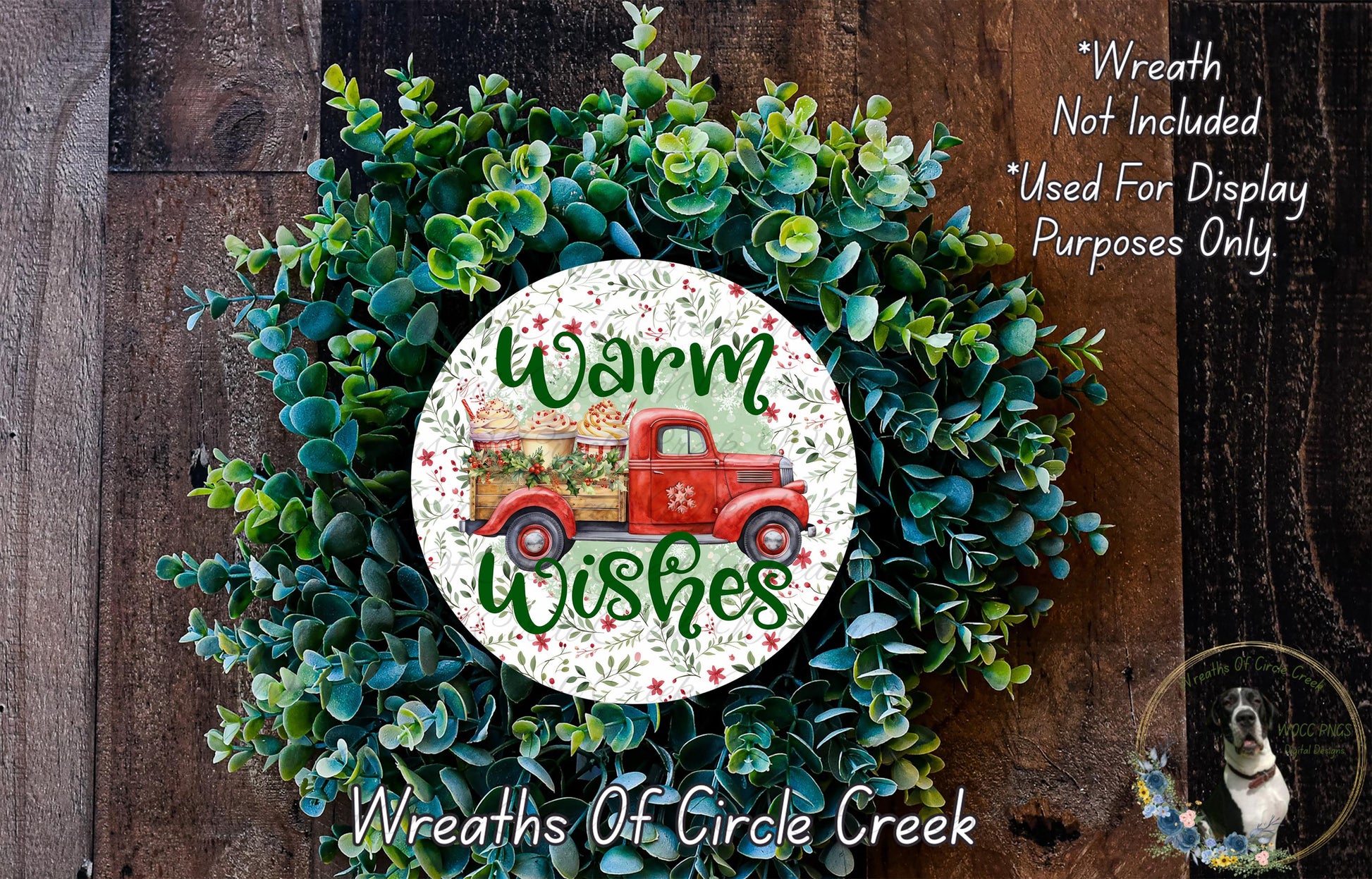 a wreath with a red truck and the text "Warm Wishes" on it, surrounded by green foliage.