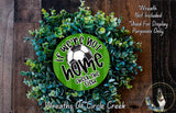 a wreath made of green leaves and a soccer ball, with the text "If we're not home, check the field" displayed on it.