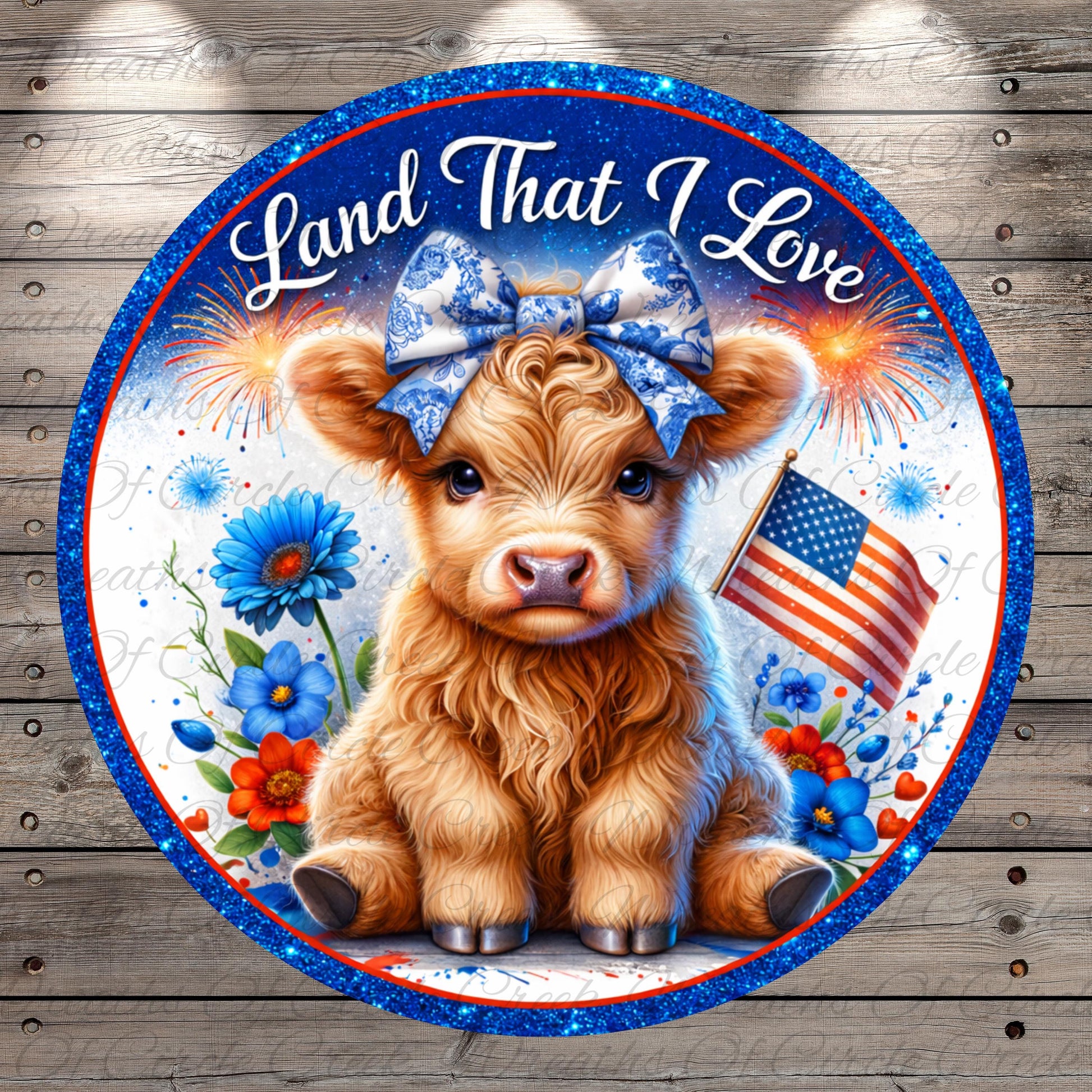 A cute brown cow with a blue bow on its head is sitting in the center of a circular frame, surrounded by flowers and an American flag. The text "Land That I Love" is written above the cow.