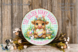 a round sign with a cartoon image of a bunny holding a heart and surrounded by Easter eggs, flowers, and a basket of food. The sign is placed on a wooden surface, and there is a small dog in the background.