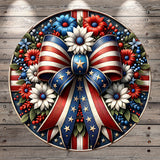 a circular arrangement of flowers, leaves, and stars, with a large American flag-inspired ribbon at the center.