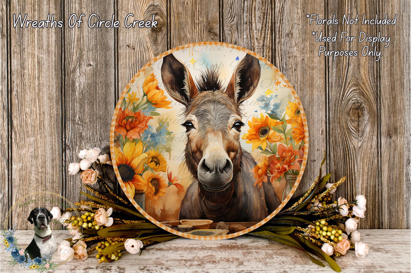 A round wooden plaque with a donkey's face on it, surrounded by a floral arrangement and a wooden background.