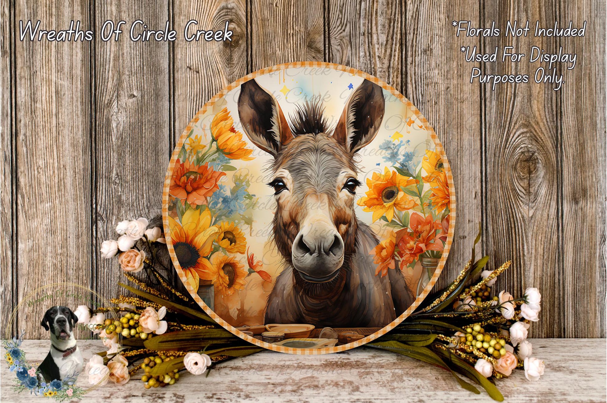A round wooden plaque with a donkey's face on it, surrounded by a floral arrangement and a wooden background.