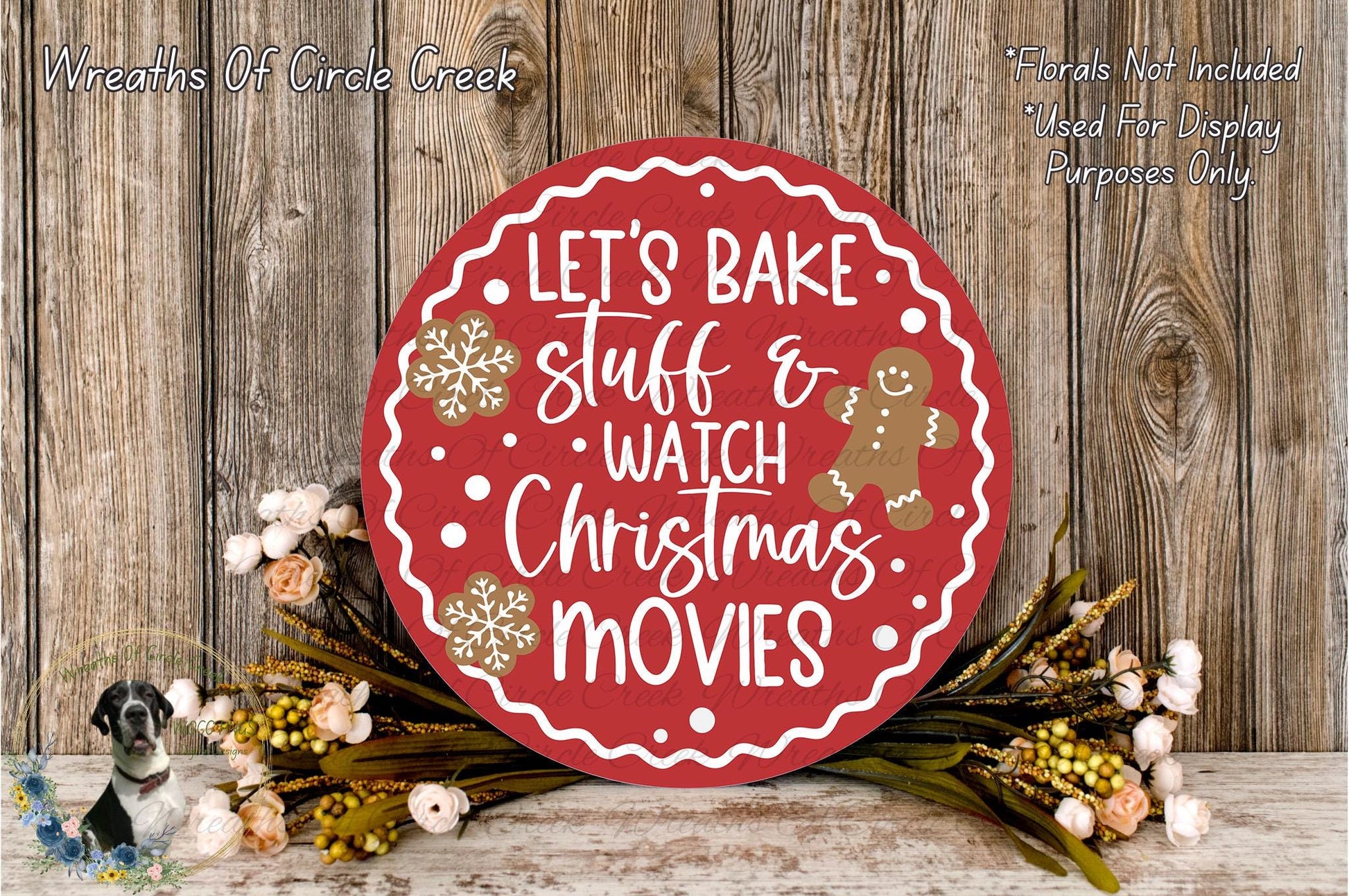 A red circular sign with white text that says "Let's Bake Stuff & Watch Christmas Movies" is surrounded by a wreath of flowers and a gingerbread man decoration.