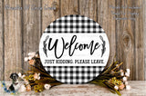 a circular sign with the text "Welcome Just Kidding. Please Leave." surrounded by a floral arrangement and a wooden background.
