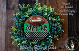 a wreath made of green and white foliage, with a football prominently displayed in the center. The wreath is described as a "Game day" wreath, suggesting it is a seasonal decoration for the celebration of a football game.
