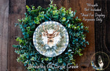 a wreath with a deer head and a bow, surrounded by green foliage. The wreath is displayed on a wooden surface, and there is a text overlay that reads "Wreath Not Included * Used For Display Purposes Only" and "Wreaths of Circle Creek".