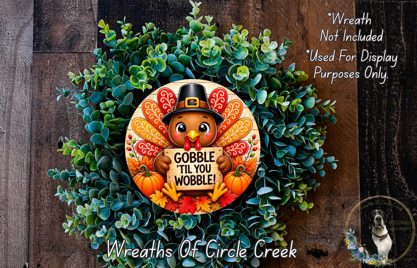 A wreath made of green leaves and a turkey wearing a hat, with the text "GOBBLE TIL YOU WOBBLE!" displayed on it.