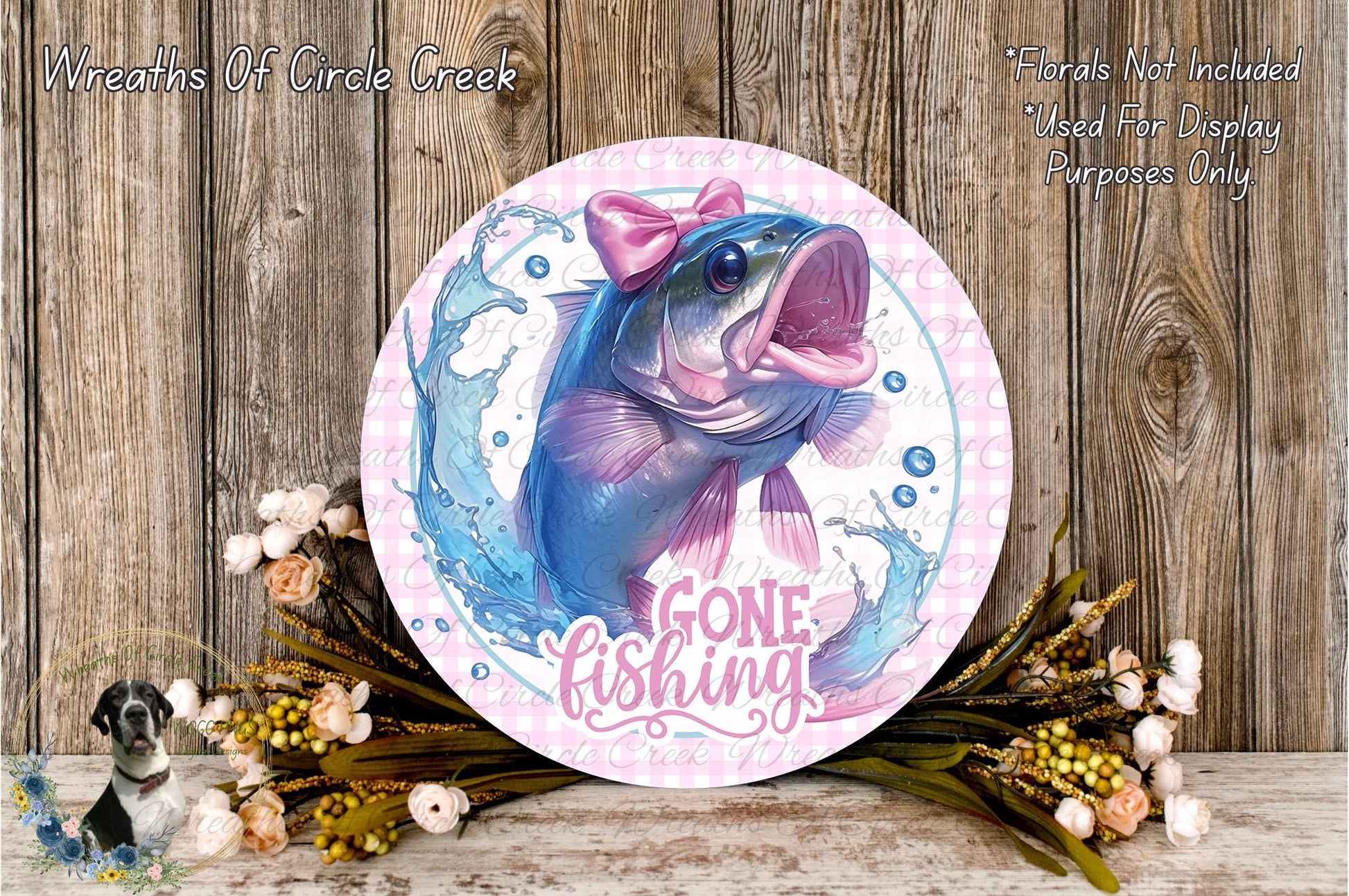 a round sign with a fish on it, surrounded by flowers and a wooden background. The sign has the text "GONE FISHING" written on it.