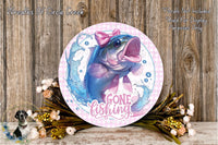a round sign with a fish on it, surrounded by flowers and a wooden background. The sign has the text "GONE FISHING" written on it.