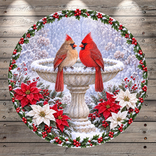 A pair of red cardinals perched on a stone bird bath, surrounded by poinsettias, berries, and a wreath of holly leaves.