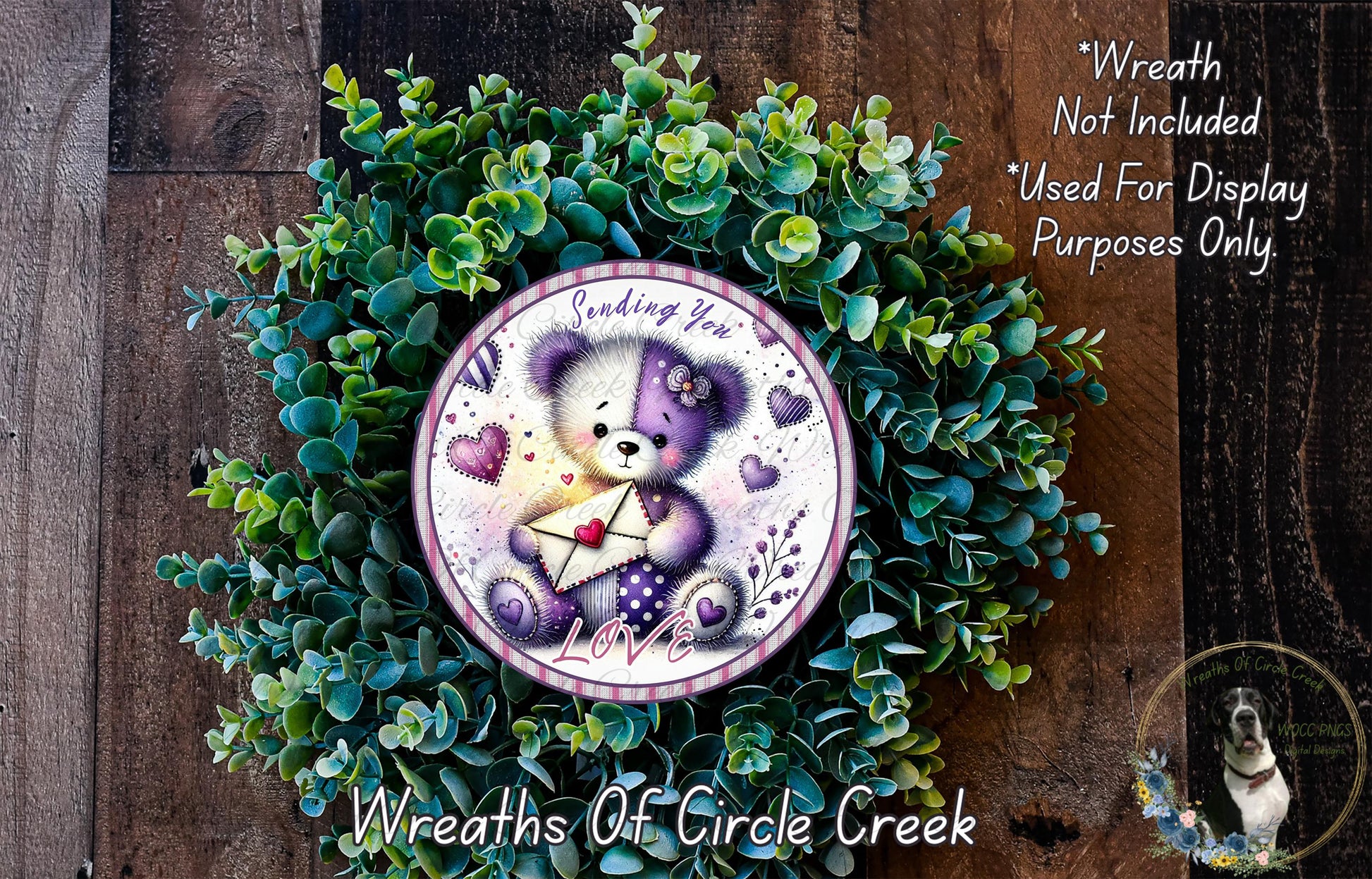 A wreath made of green leaves and a purple and white teddy bear holding a heart-shaped envelope, with the text "Sending You Love" on the wreath.