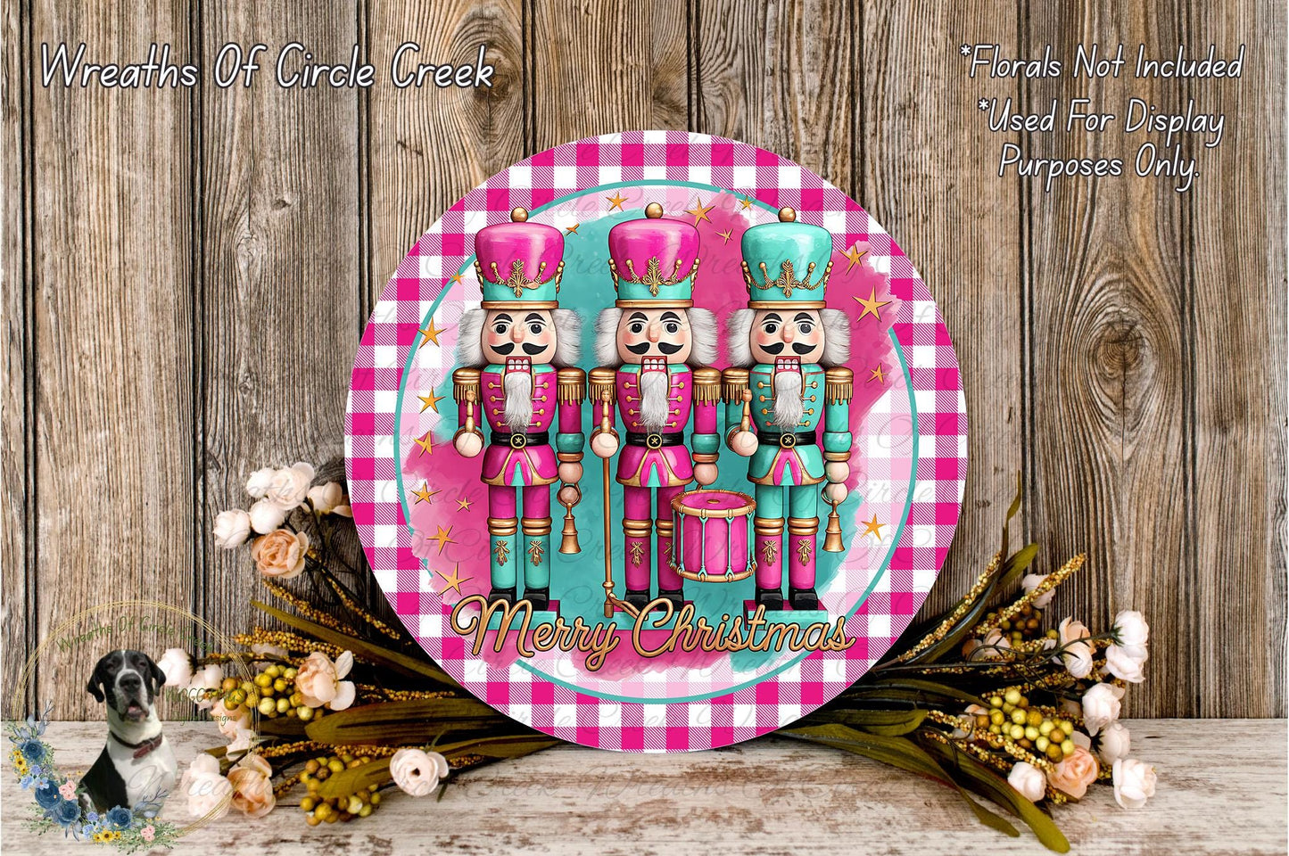 A decorative plate featuring three nutcracker dolls in pink and blue outfits, surrounded by a floral arrangement and a "Merry Christmas" message.