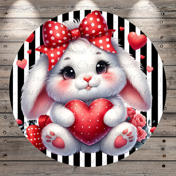 A cute white bunny with a red polka dot bow is holding a red heart-shaped object in the center of the image, surrounded by red hearts and flowers against a black and white striped background.