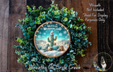 A wreath made of green plants and a decorative plate featuring a desert scene with a cactus and a snowman.