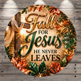 The image is a circular graphic with a wooden background and a cross, surrounded by autumn leaves and flowers. The text on the graphic reads "Fall for Jesus he never leaves".