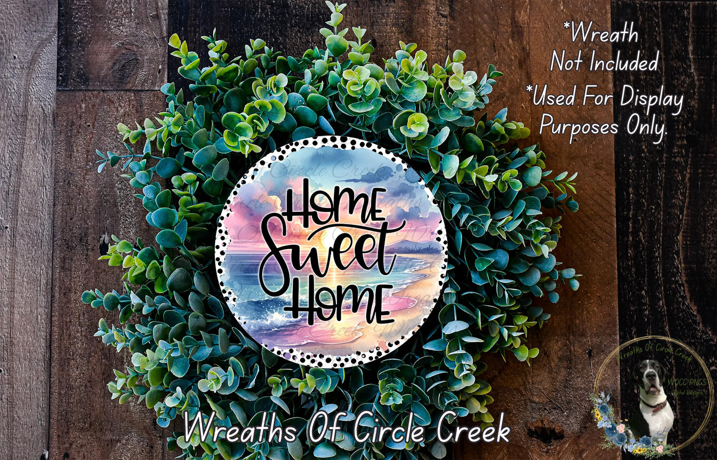 a wreath made of various green plants and flowers, with a circular design in the center that says "Home Sweet Home".