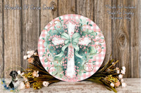 a round wooden plaque with a cross design, surrounded by a floral arrangement and a wooden background.